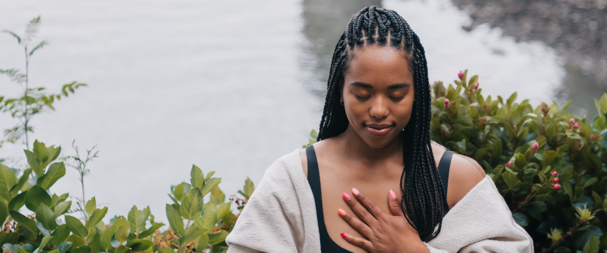 woman meditating by river during life coaching