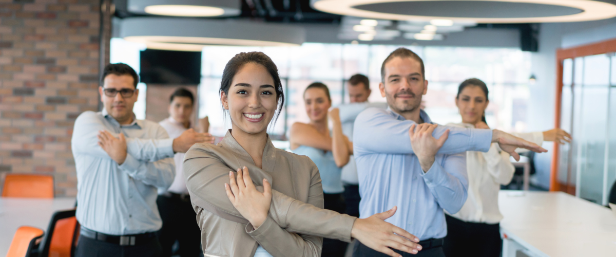 Group of coworkers in office stretching for workplace wellness