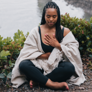 woman meditating by river during life coaching