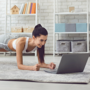 woman doing personal training at home on floor in front of laptop